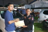 Sekretaris BPPKB Ranting Cibodas Baru, Nurfadlysyach (kiri) saat menerima berkas kepe ngurusan dari Bambang, Penasehat DPAC BPPKB Cibodas. (Foto/fad)