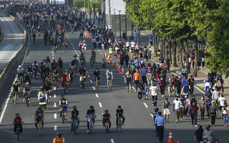 Warga berolahraga saat hari bebas berkendara atau Car Free Day (CFD) di kawasan Jalan M.H. Thamrin, Jakarta, Minggu (21/6/2020). Dinas Perhubungan (Dishub) Provinsi DKI Jakarta memisahkan jalur untuk pesepeda, olahraga lari, dan jalan kaki saat CFD pertama pada masa pembatasan sosial berskala besar (PSBB) transisi. ANTARA FOTO/Galih Pradipta/foc.
