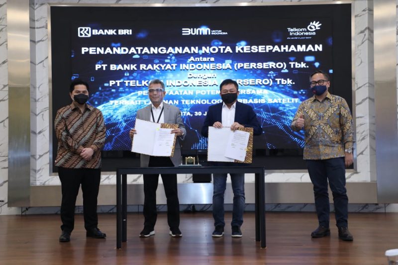 Direktur Utama Telkom Ririek Adriansyah (kedua dari kanan) bersama Direktur Utama Bank Rakyat Indonesia Sunarso (kedua dari kiri) usai penandatanganan nota kesepahaman terkait kolaborasi layanan teknologi berbasis satelit disaksikan Menteri BUMN RI Erick Thohir (paling kiri) dan Wakil Menteri II BUMN Kartika Wirjoatmodjo (paling kanan) di Jakarta, Kamis (30/7).