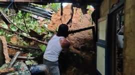 Seorang warga membantu membersihkan puing rumah yang hancur akibat tanah longsor di Kelurahan Remu Selatan, Kecamatan Sorong Manoi, Kota Sorong, Papua Barat, Sabtu (19/9)