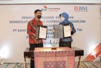 Direktur Finance & Business Support PTPL Catur Dermawan dan Pemimpin Divisi Bisnis Korporasi 2 PT Bank BNI Ditya Maharhani Harninda menunjukkan dokumen Penandatanganan Kerja Sama Pemberian Fasilitas Distributor Financing yang diselenggarakan di Jakarta / Foto Ist