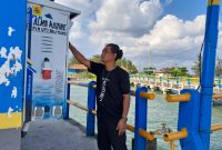 Seorang Anak Buah Kapal (ABK) menggunakan Anjungan Listrik Mandiri (ALMA) untuk keperluan kapal selama bersandar di Dermaga Water Front, Pelabuhan Tanjung Ru, Belitung. ALMA membuat para pelaku usaha perikanan dan perkapalan dapat melakukan penghematan biaya operasionalnya. Karena tidak tergantung lagi dengan bahan bakar minyak untuk mengoperasikan genset saat bersandar.