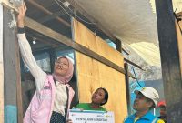 Shila tengah menyalakan secara simbolis dan mewujudkan mimpi Muliati (41) warga Kelurahan Rappojawa Kota Makassar untuk mendapatkan akses listrik gratis dalam program 
