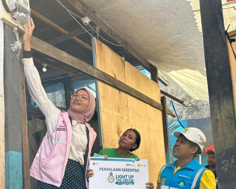 Shila tengah menyalakan secara simbolis dan mewujudkan mimpi Muliati (41) warga Kelurahan Rappojawa Kota Makassar untuk mendapatkan akses listrik gratis dalam program 