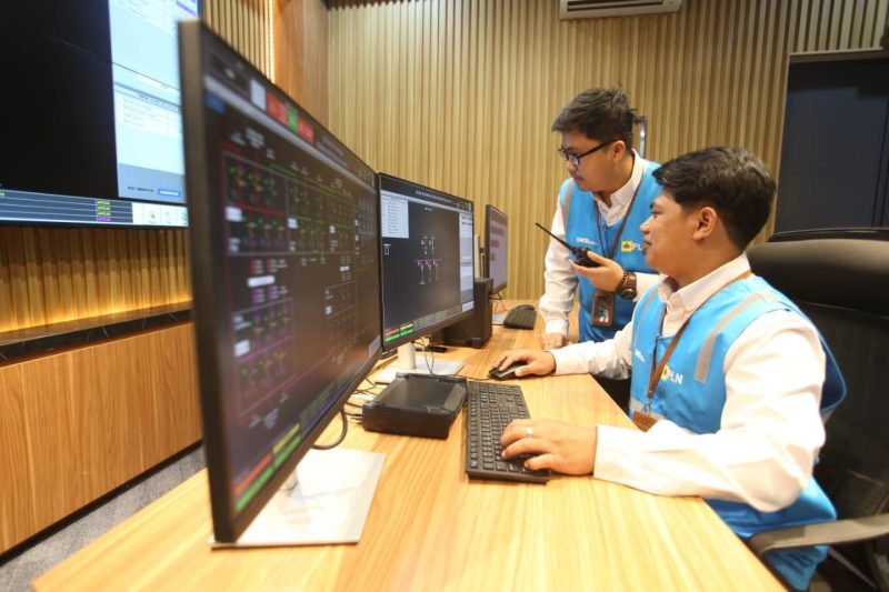 Pertugas PLN Kandung Dwi Ridho Pangestu (duduk) dan Andi Maranatha Tobing (berdiri) saat berkoordinasi memastikan sistem jaringan kelistrikan di Istana Kepresidenan Jakarta dalam kondisi yang aman.