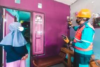 Ilustrasi petugas PLN melakukan pengecekan pada instalasi listrik pelanggan sebelum melakukan penambahan daya.