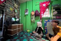 Mia Annisa, 29 tahun (kiri) dan Ramzi, 19 tahun (kanan) warga kecamatan Teluk Belengkong, Kabupaten Indragiri Hilir, Provinsi Riau kini bisa menikmati listrik PLN selama 24 jam.