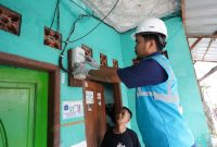 Petugas PLN melakukan pengecekan kWh meter di salah satu rumah pelanggan di Jakarta.