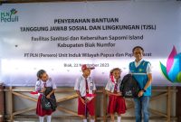Simbolis penyerahan bantuan berupa alat-alat sekolah kepada pelajar SD Inpres Bridge 2 oleh Direktur Distribusi PLN, Adi Priyanto (kanan).