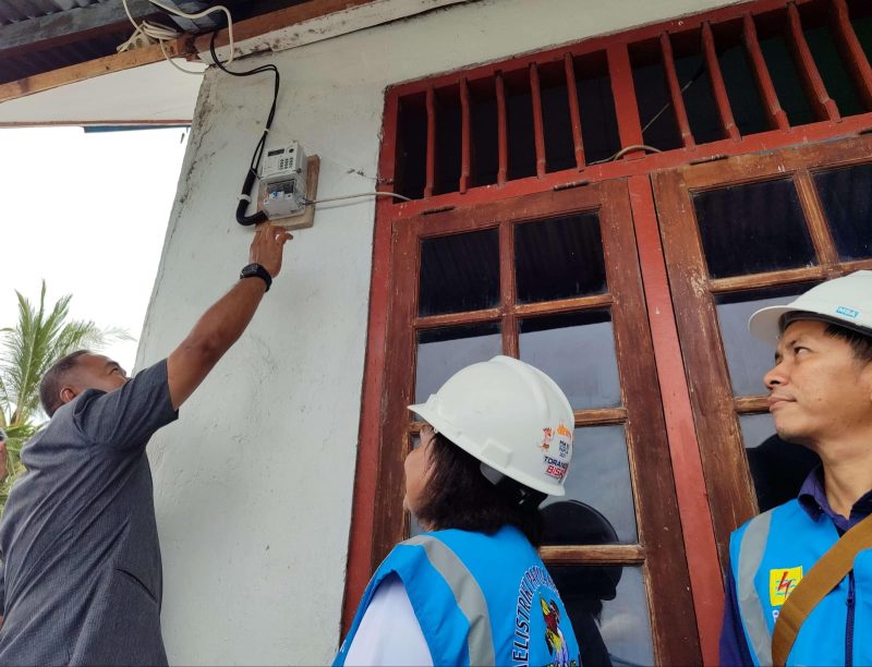 Pj Bupati Jayapura, Triwarno Purnomo (kiri) ketika melakukan penyalaan listrik di salah satu rumah warga. Dirinya menyampaikan apresiasinya atas upaya PLN yang sukses menyalakan listrik bagi masyarakat tiga desa di wilayahnya.