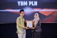 Penyerahan penghargaan Indonesia Fundraising Award (IFA) 2023 secara simbolis kepada Pengurus YBM PLN, Irianto Resi (kiri).