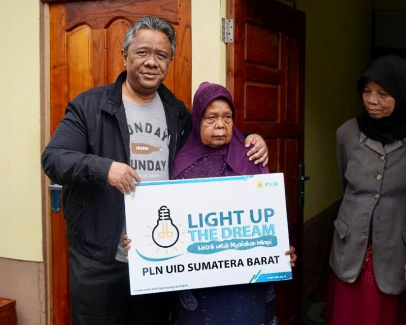 Penyerahan bantuan pengambungan listrik gratis program Light Up The Dream kepada Rosnida (tengah) warga desa Garegeh, Kecamatan Mandiangin Koto Selayan, Kota Bukittinggi oleh Direktur Legal dan Manajemen Human Capital PLN Yusuf Didi Setiarto (kiri).