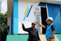 Petugas PLN beserta petugas keamanan lingkungan setempat saat melakukan pengecekan gardu distribusi listrik yang terbuat dari FABA.