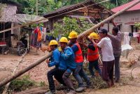 Petugas PLN gotong royong bersama masyarakat memperbaiki tiang listrik yang roboh akibat bencana banjir dan longsor yang menerjang Kabupaten Pesisir Selatan, Sumatera Barat, pada Senin (11/3).