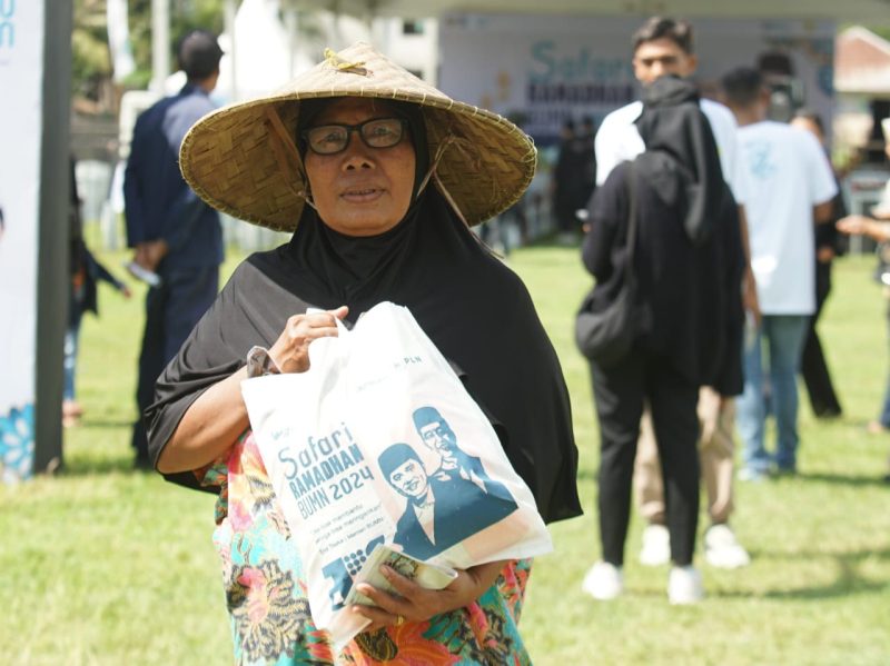 Seorang warga Desa Puyung, Lombok Tengah membawa paket sembako murah yang didapat dari acara Safari Ramadhan BUMN 2024.