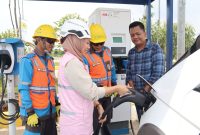 Widya Eka Kristanti, Manager PLN ULP Sukadana (kedua dari kiri) sedang membantu pengguna mobil listrik yang melakukan pengisian daya di SPKLU Rest Area Tol Trans Sumatra KM 116B.