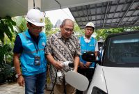 General Manager PLN UID Jakarta Raya Lasiran (kiri) dan Senior Manager Niaga dan Manajemen Pelanggan PLN UID Jakarta Raya Inu Suprianto (kanan) mendampingi pelanggan melakukan pengisian daya mobil listrik menggunakan home charging.