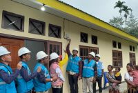 Penyalaan listrik secara simbolis oleh General Manager PLN Unit Induk Wilayah Papua dan Papua Barat, Budiono (tengah) yang disaksikan oleh masyarakat Kampung Banda, Distrik Waris Kabupaten Keerom, Papua.