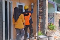 Petugas PLN melakukan tambah daya listrik di rumah Nurul Chotimah, pelanggan yang memanfaatkan program promo 