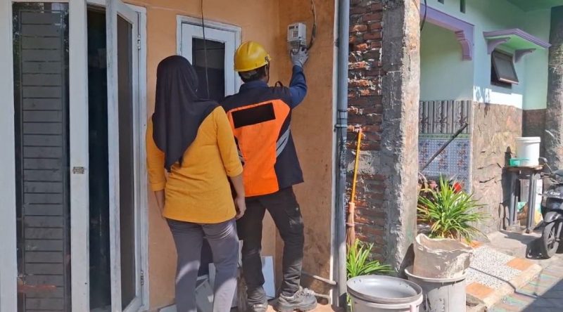 Petugas PLN melakukan tambah daya listrik di rumah Nurul Chotimah, pelanggan yang memanfaatkan program promo 