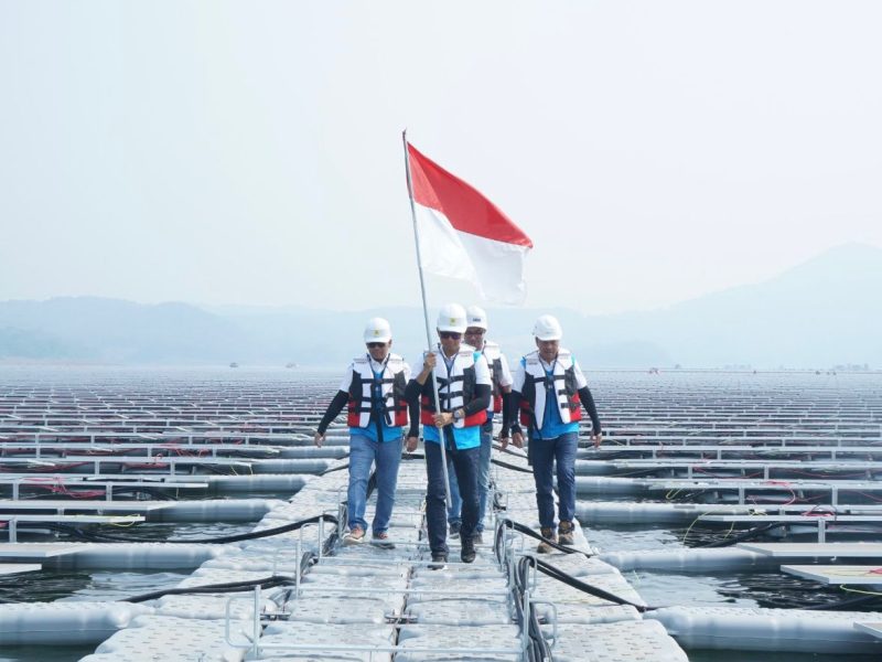 Direktur Utama PLN Darmawan Prasodjo (kedua dari kiri) didampingi Direktur Manajemen Pembangkitan PLN Adi Lumakso (kiri), Direktur Utama PLN Nusantara Power Ruly Firmansyah (kanan), dan Managing Director Masdar Asia Pacific, Sujit S. Parhar (kedua dari kanan) berjalan diantara panel surya untuk memasang bendera merah putih saat meninjau pembangkit listrik tenaga surya (PLTS) terapung Cirata di Purwakarta, Jawa Barat. Kehadiran PLTS ini menjadi bukti bahwa PLN mampu menjadikan transisi energi menjadi sebuah kekuatan untuk meningkatkan ketahanan energi nasional.