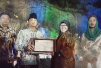Manager PLN Unit Pelaksana Pelayanan Pelanggan Ponorogo Suzana Zein (dua dari kanan) bersama Bupati Trenggalek, Mochamad Nur Arifin (dua dari kiri) menandatangani Nota Kesepahaman terkait penggunaan REC oleh Pemerintah Kabupaten Trenggalek pada rangkaian Grand Final Putri Otonomi Indonesia (POI) 2024, di Tebing Kapuh, Kabupaten Trenggalek, Jum’at (07/06). Turut menyaksikan penandatanganan Ketua Asosiasi Pemerintah Kabupaten Seluruh Indonesia (APKASI) dan Sutan Riska Tuanku Kerajaan (kiri) dan Ketua Tim Penggerak PIKK Kabupaten Trenggalek Novita Hardini Mochamad (kanan).