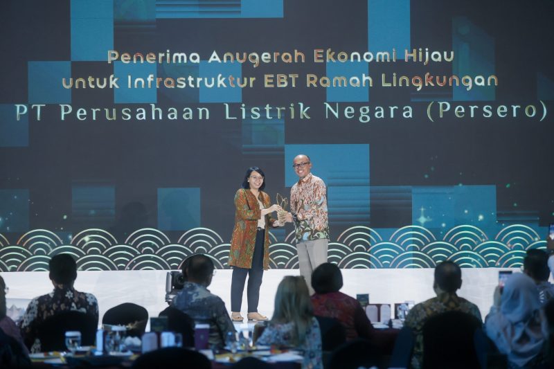 Direktur Manajemen Produk Detik Network Sena Achari (kiri) menyerahkan Anugerah Ekonomi Hijau untuk Infrastruktur EBT Ramah Lingkungan kepada PLN yang diwakili oleh Direktur Transmisi dan Perencanaan Sistem PLN Evy Haryadi di Jakarta pada Selasa (30/7).