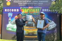 Direktur Operasional Museum Rekor Indonesia (MURI), Yusuf Ngadri (kiri) menyerahkan piagam rekor MURI untuk “Pengisian Daya Listrik Pada Mobil Listrik Terbanyak di Satu Lokasi” kepada Ketua Umum WEVI (Wuling Electric Vehicle Indonesia) Deni Sukatno (kanan), di Bandung, Sabtu (13/7).