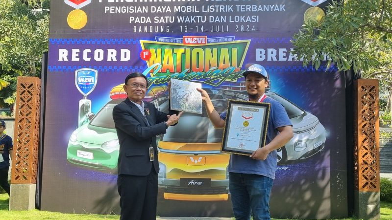 Direktur Operasional Museum Rekor Indonesia (MURI), Yusuf Ngadri (kiri) menyerahkan piagam rekor MURI untuk “Pengisian Daya Listrik Pada Mobil Listrik Terbanyak di Satu Lokasi” kepada Ketua Umum WEVI (Wuling Electric Vehicle Indonesia) Deni Sukatno (kanan), di Bandung, Sabtu (13/7).