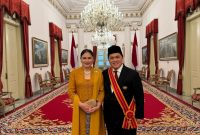 Menteri Badan Usaha Milik Negara Erick Thohir (kanan) didampingi sang istri berfoto setelah menerima gelar tanda kehormatan Bintang Mahaputera Adipradana dari Presiden Republik Indonesia Joko Widodo di Istana Negara, pada hari Rabu (14/8).