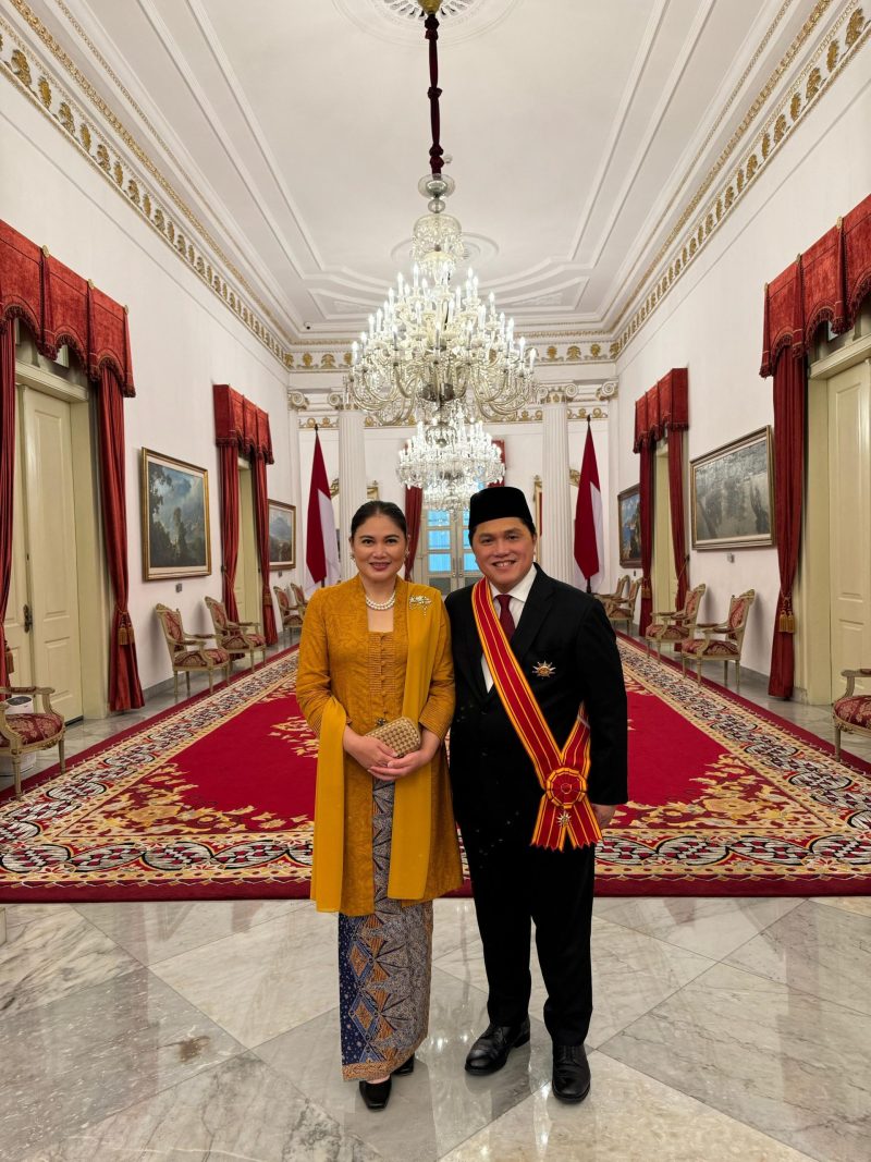 Menteri Badan Usaha Milik Negara Erick Thohir (kanan) didampingi sang istri berfoto setelah menerima gelar tanda kehormatan Bintang Mahaputera Adipradana dari Presiden Republik Indonesia Joko Widodo di Istana Negara, pada hari Rabu (14/8).