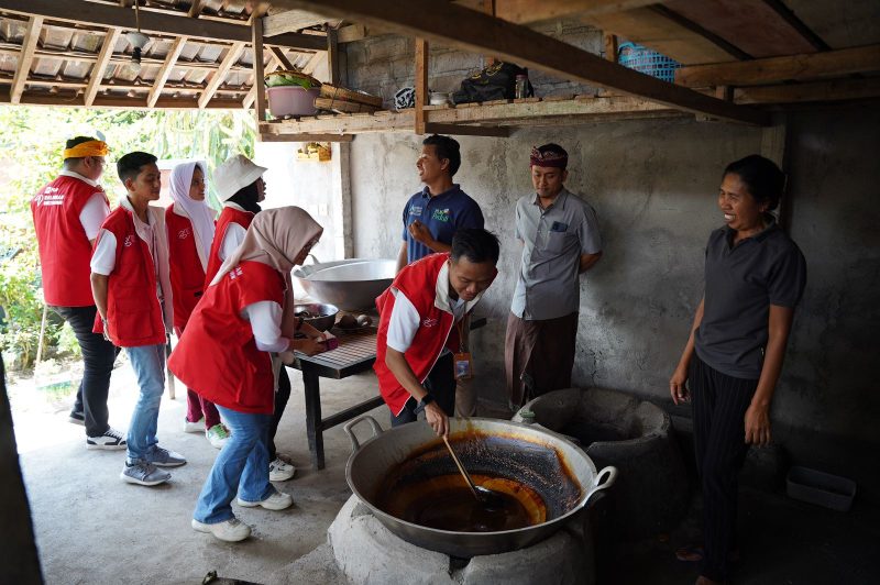 Relawan Bakti BUMN saat mengaduk gula semut sebagai produk unggulan Desa Manistutu, Jembrana, Bali.