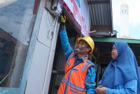 Rona bahagia terpancar dari wajah Jumaidah (kanan) penerima manfaat program Light Up The Dream di Kecamatan Gandus, Palembang  oleh petugas PLN.