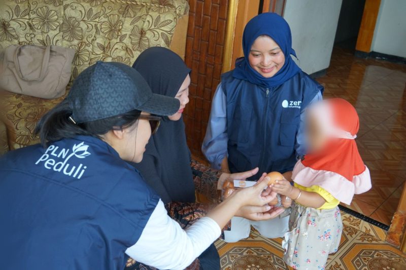 Petugas PLN membagikan telur gratis kepada salah satu anak terindikasi stunting di Desa Karangkates, Kabupaten Malang (10/10) dalam Program Zero Stunting Eggcellent. Guna memperbaiki asupan gizi, sebanyak 250 anak terindikasi stunting secara kontinyu selama 6 bulan akan diberikan telur gratis yang merupakan hasil budi daya ayam petelur pemberian PLN.