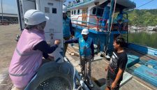 Petugas PLN (kiri) ketika sedang berbincang dengan salah seorang pemilik kapal ikan, Hutagalung (kanan) yang sedang menggunakan ALMA saat kapalnya bersandar di Tempat Pelelangan Ikan (TPI) Kecamatan Sarudik, Kabupaten Tapanuli Tengah, Sumatera Utara.