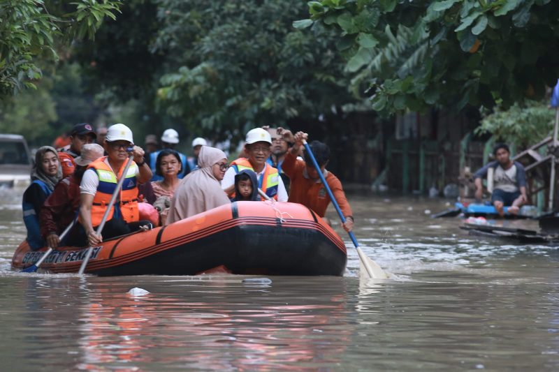 Direktur Utama PLN Darmawan Prasodjo (kiri depan), Direktur Distribusi PLN Adi Priyanto (kanan depan) dan Tim Badan Penanggulangan Bencana Daerah (BPBD) Bekasi ketika mengevakuasi korban banjir dengan perahu karet di Perumahan Nasional 1 Kayuringin Jaya, Bekasi, Jawa Barat pada Selasa (4/3).