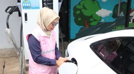 Estuning Rahayu ketika membantu mengisi daya kendaraan listrik milik pelanggan pada periode arus balik mudik lebaran 1446 H.
