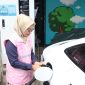 Estuning Rahayu ketika membantu mengisi daya kendaraan listrik milik pelanggan pada periode arus balik mudik lebaran 1446 H.