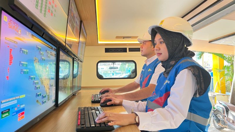 Ilustrasi petugas PLN sedang bersiaga memantau kondisi sistem kelistrikan menggunakan mini scada mobile.