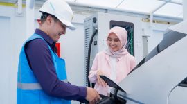 Ilustrasi pengguna electric vehicle dibantu oleh Petugas PLN ketika mengisi kendaraan listriknya di SPKLU.