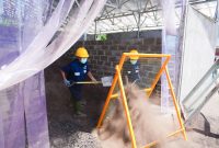 Para warga binaan Lapas Nusakambangan menyaring FABA sebelum dimasukkan ke dalam mesin press untuk diolah menjadi produk konstruksi bernilai ekonomi di Workshop FABA PLN, Nusakambangan.