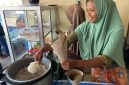 Keterangan Foto 2: Ibu Rizal, pemilik Rumah Makan sedang melayani pelanggan makan di tempat di seberang Pertamina Mandalika International Circuit, Kamis (2/10).