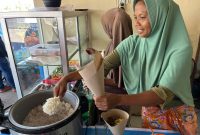 Keterangan Foto 2: Ibu Rizal, pemilik Rumah Makan sedang melayani pelanggan makan di tempat di seberang Pertamina Mandalika International Circuit, Kamis (2/10).