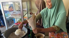 Keterangan Foto 2: Ibu Rizal, pemilik Rumah Makan sedang melayani pelanggan makan di tempat di seberang Pertamina Mandalika International Circuit, Kamis (2/10).