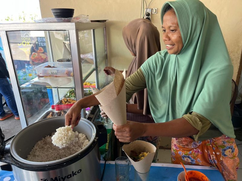 Keterangan Foto 2: Ibu Rizal, pemilik Rumah Makan sedang melayani pelanggan makan di tempat di seberang Pertamina Mandalika International Circuit, Kamis (2/10).