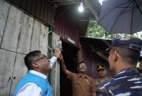 Direktur Perencanaan Korporat dan Pengembangan Bisnis PLN, Hartanto Wibowo (kiri), menyalakan sambungan listrik di salah satu rumah penerima manfaat program 