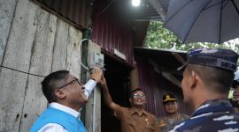 Direktur Perencanaan Korporat dan Pengembangan Bisnis PLN, Hartanto Wibowo (kiri), menyalakan sambungan listrik di salah satu rumah penerima manfaat program 