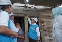 Direktur Transmisi dan Perencanaan Sistem PLN, Edwin Nugraha Putra (kedua dari kanan) bersama General Manager PLN Unit Induk Distribusi Sumatera Utara, Ahmad Syauki (kiri), dan General Manager Unit Induk Penyaluran dan Pusat Pengatur Beban Sumatera, Amirrudin (kedua dari kiri) secara simbolis menyalakan lampu rumah Marluga Marbun (tengah), salah satu penerima manfaat program penyambungan listrik gratis 