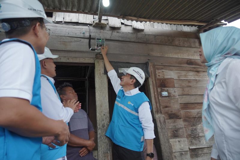 Direktur Transmisi dan Perencanaan Sistem PLN, Edwin Nugraha Putra (kedua dari kanan) bersama General Manager PLN Unit Induk Distribusi Sumatera Utara, Ahmad Syauki (kiri), dan General Manager Unit Induk Penyaluran dan Pusat Pengatur Beban Sumatera, Amirrudin (kedua dari kiri) secara simbolis menyalakan lampu rumah Marluga Marbun (tengah), salah satu penerima manfaat program penyambungan listrik gratis