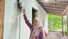 Karmini, warga Desa Ngandul, Kabupaten Sragen, Jawa Tengah di depan meter listrik miliknya sendiri, bantuan pemasangan listrik gratis dari PLN. Kini ia bisa menikmati listrik secara mandiri tanpa harus menumpang lagi.
